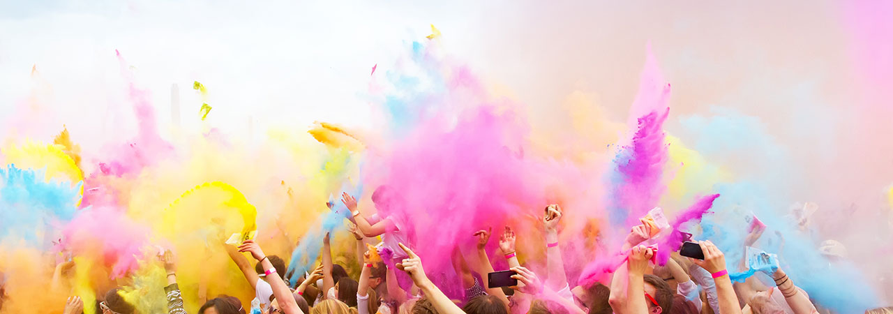 Mehrere Menschen auf einem Holyfestival bewerfen sich mit Farbpulver