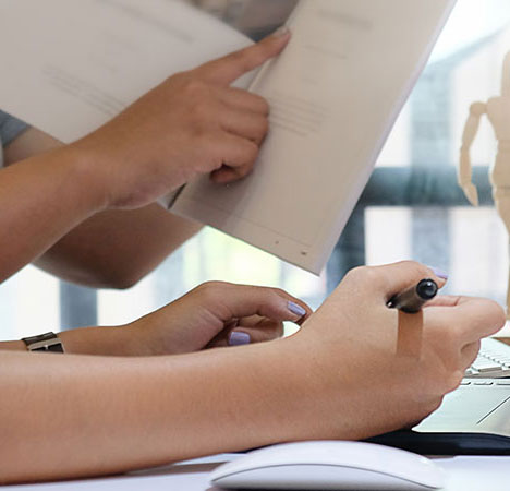 Eine Hand zeigt auf eine Zeile in einem Magazin, eine andere Hand hält einen Stift